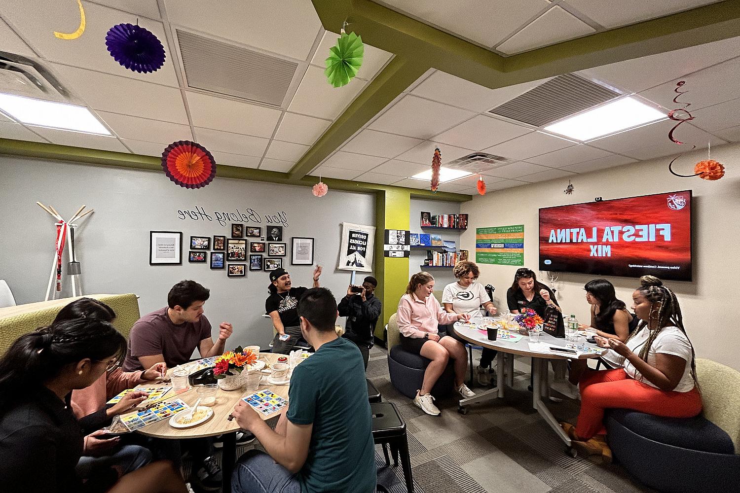 Students sitting at round tables playing games.